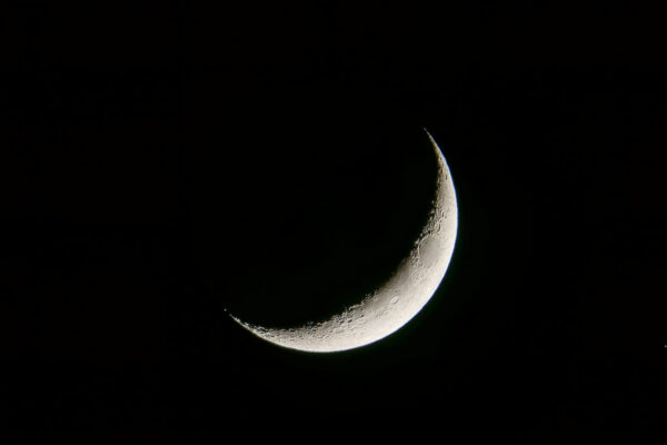 Sichelförmiger Mond mit Kratern am Nachthimmel