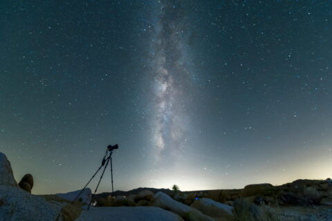 Kamera auf Stativ für Astrofotografie unter sternenklarer Nacht mit der Milchstraße im Hintergrund.